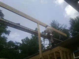 Carpenter setting a ridge beam over a new addition frame — Ice Dam Removal by Roofing Brothers in Waukesha