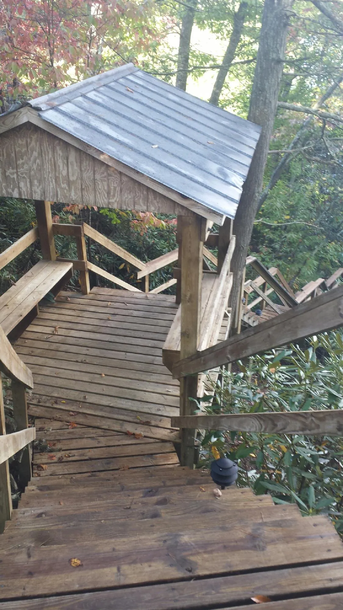 Metal roofed shelter over wooden steps on a wooded walkway — Skylight Repair & Installation work by our crew in Waukesha