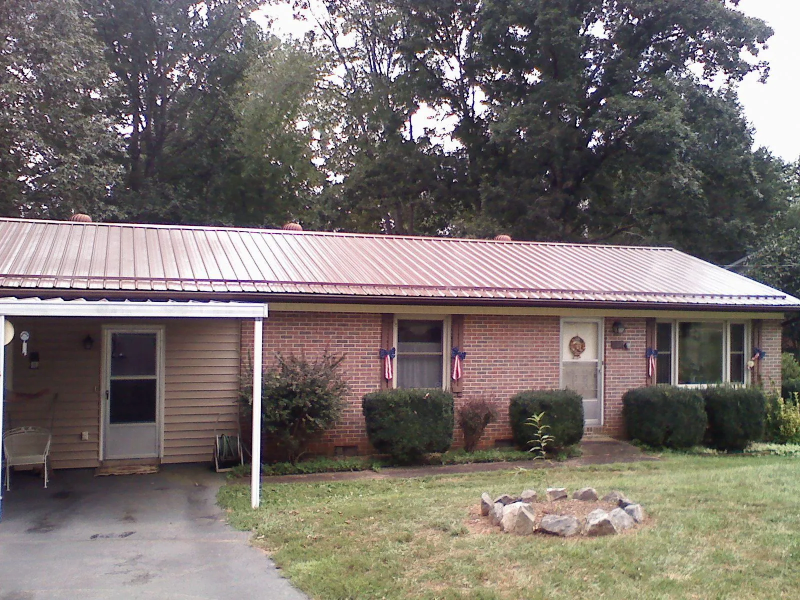 Bronze metal roof and carport on a brick ranch home — Roof Repair work by our crew in Waukesha