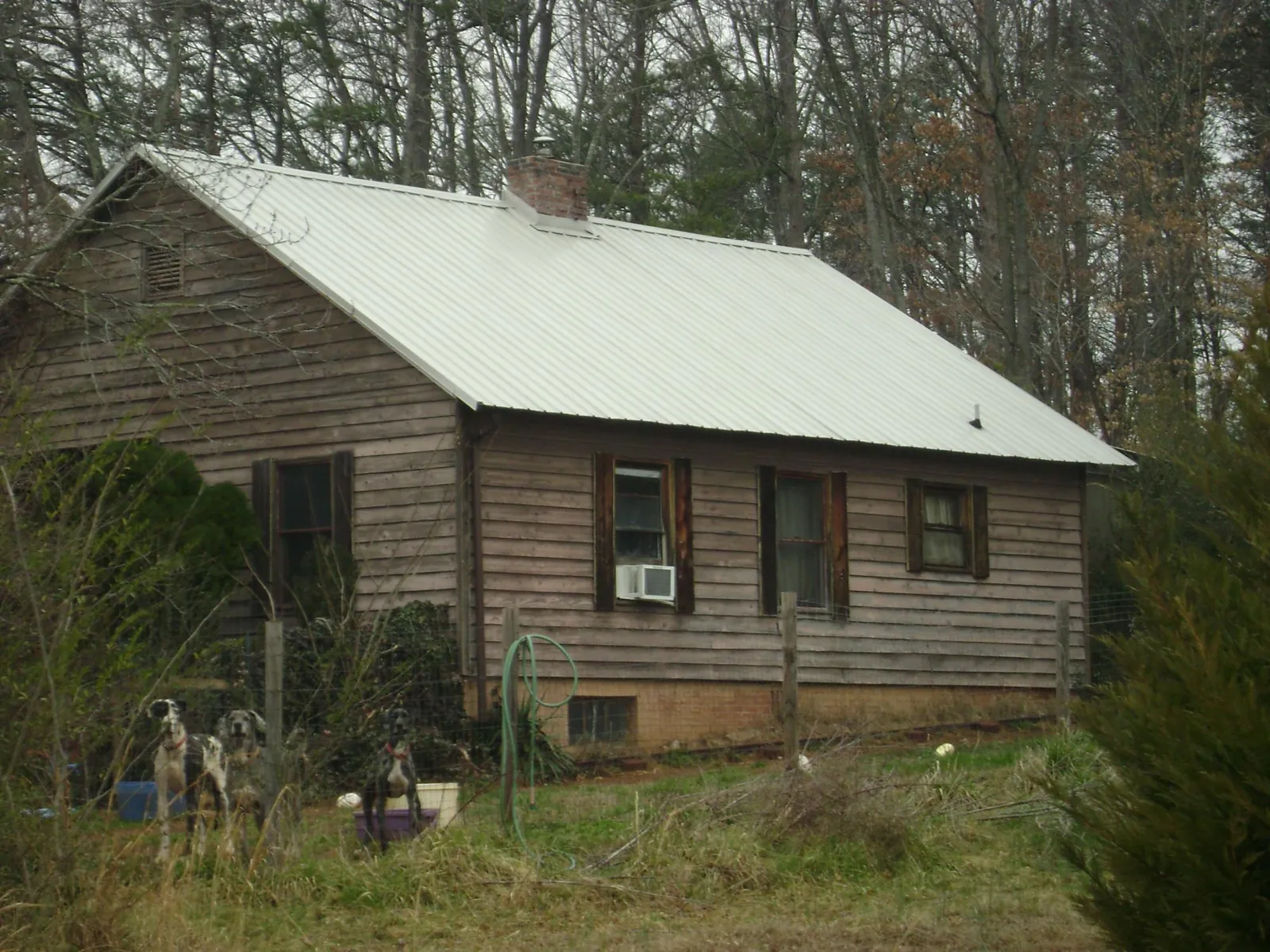 White metal roof on an old wood sided farmhouse, from a Asphalt Shingle Roof Repair job in Waukesha